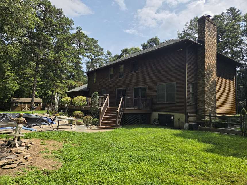 Rear of a New Jersey colonial we bought as-is, with deck and brick chimney